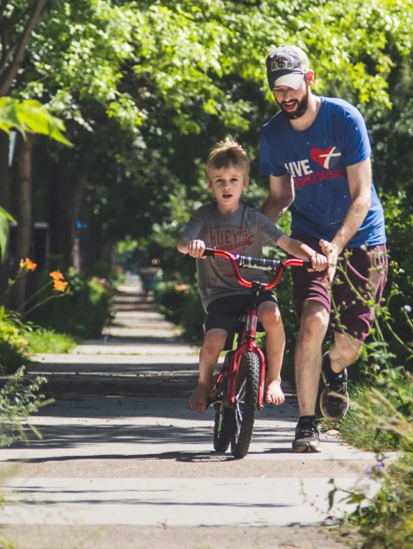 Eric helping a child ride a bicycle